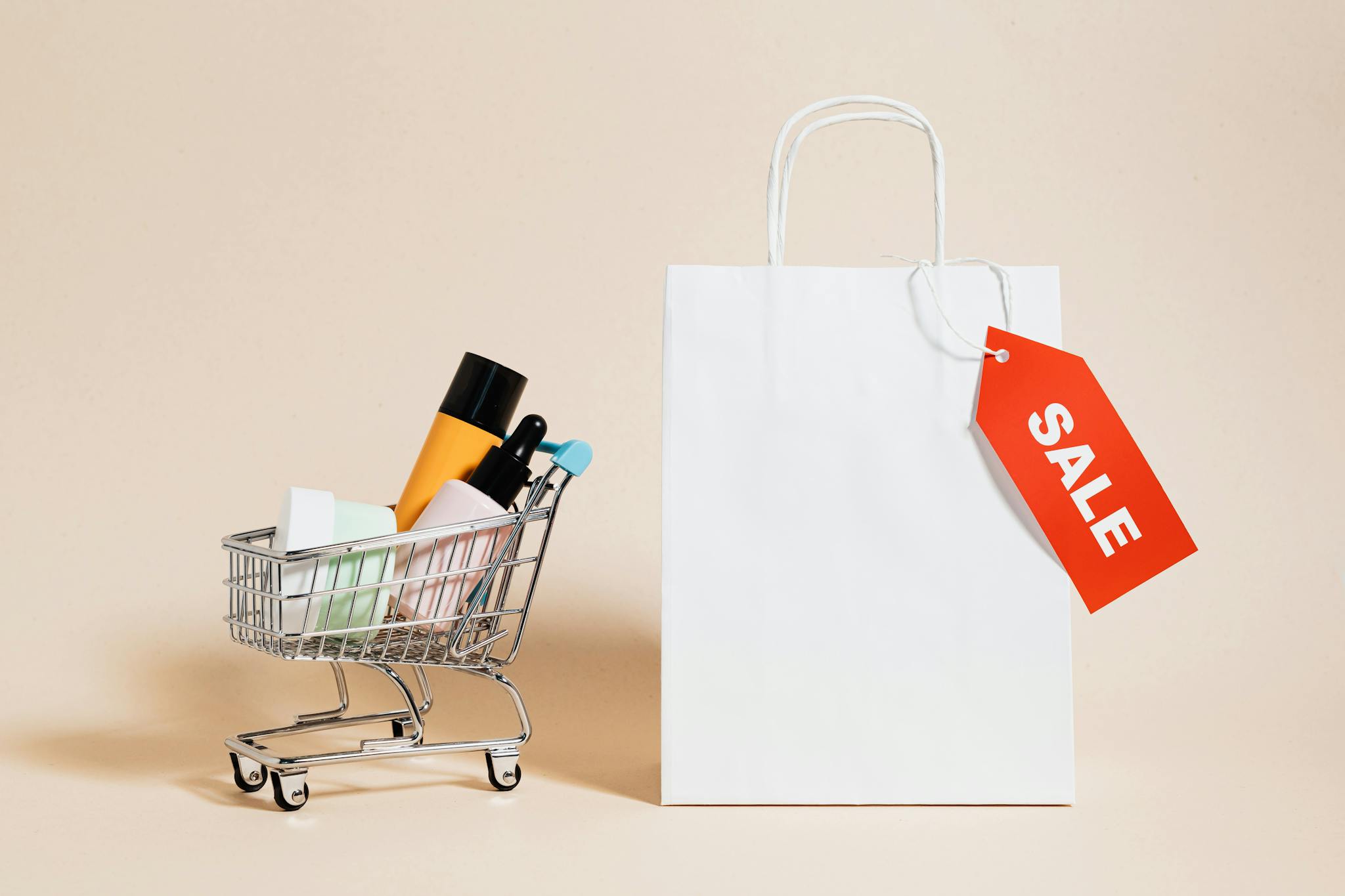 Minimalist image featuring a shopping cart with products and a sale-tagged bag.
